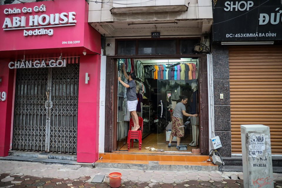  越南全国社交距离措施从自2020年4月1日零时起至23日零时起实施。4月23日是正式放宽社会距离措施的第一天，首都河内的生活在逐渐恢复中。静寂的街头开始热闹起来，街头的车辆和行人都在增加。今天也是各家非必需品商店重新开门迎客的第一天。图为河内市一家商店一大早就准备开门迎客。Vietnam+记者 明山 摄