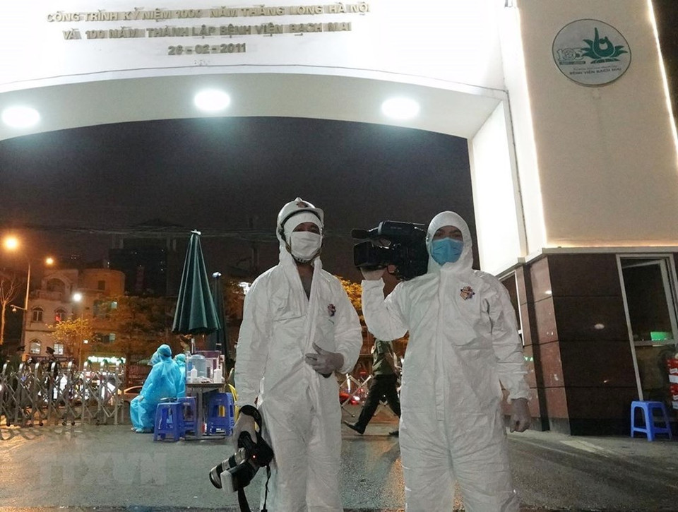 阳江记者于2020年3月28日报道白梅医院封锁和消毒事件。记者都穿防护服。图自越通社