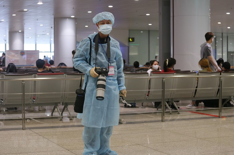 越通社摄影记者辉雄在内排国际机场作业。图自越通社