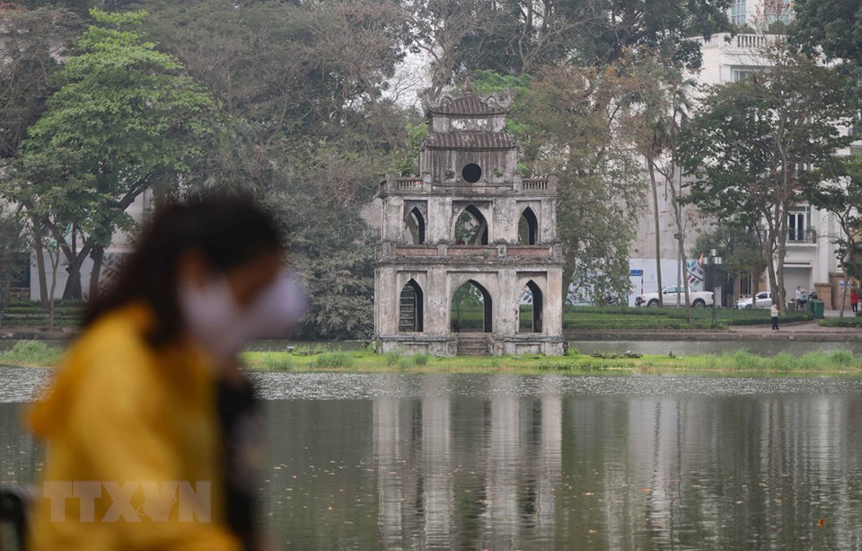 还剑湖周边散步和锻炼身体的人都佩戴口罩。图自越通社