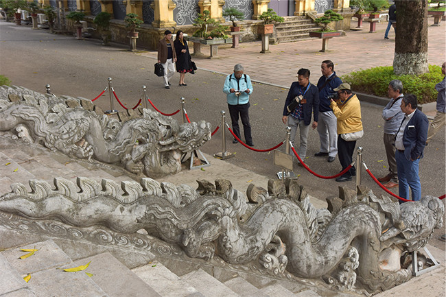 许多游客被敬天殿的两条石龙吸引住。（图片来源：《人民报网》）
