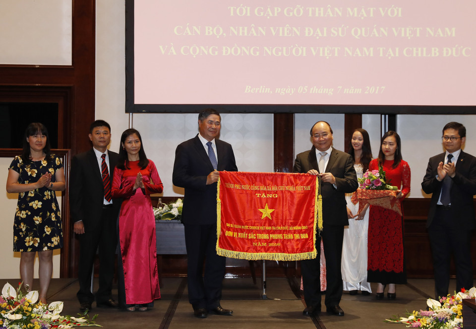 阮春福总理向越南驻德大使馆授予越南政府的竞赛锦旗。（图片来源：越通社）