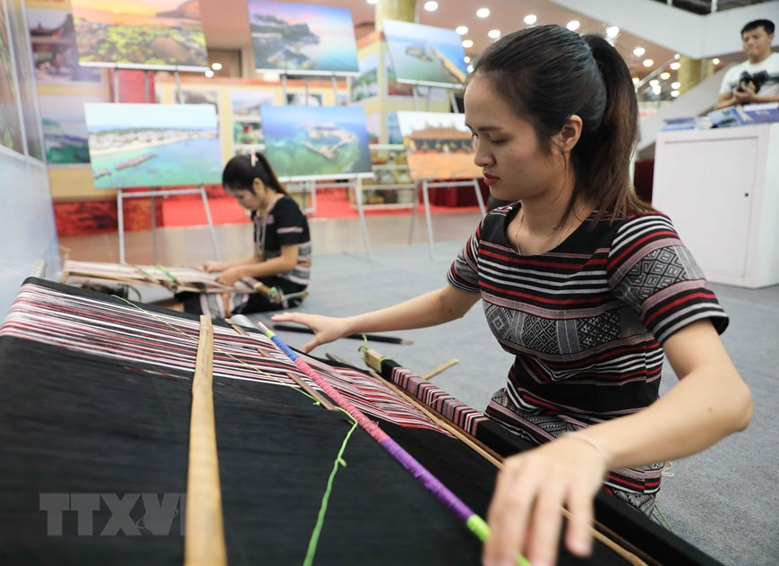 广南省少数民族同胞现场展示土锦编织技术。越通社记者青松 摄