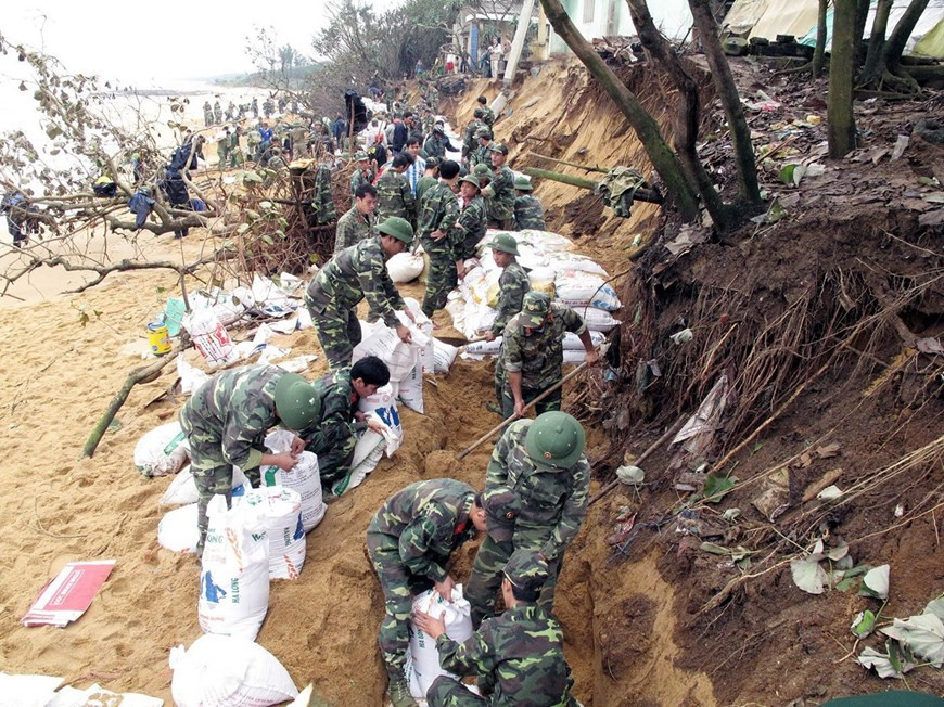 部队力量建设海岸防护堤坝，以防止海水入侵。（图自越通社）