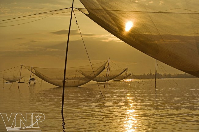 ​张网捕鱼是秋盆水乡居民的传统捕鱼方式（图片来源：越通社）