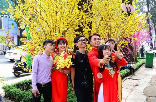 年经人同梅花拍照 （图片来源：越南《人民军队报》）