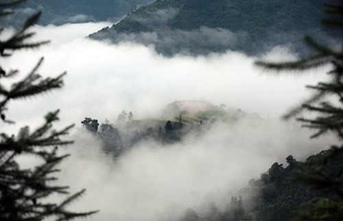 山峰与白云融为一体，构成了一幅虚幻空灵的画面。（图片来源：人民军队报网）