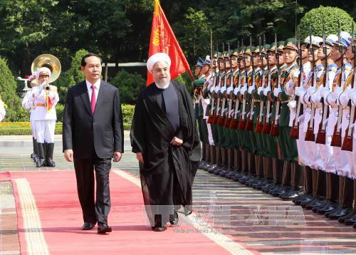 越南国家主席陈大光与伊朗伊斯兰共和国总统哈桑•鲁哈尼检阅越南人民军队仪仗队。（图片来源：越通社）