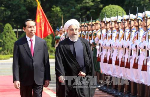 越南国家主席陈大光与伊朗伊斯兰共和国总统哈桑•鲁哈尼检阅越南人民军队仪仗队。（图片来源：越通社）