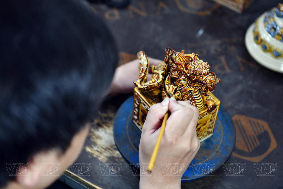每一件龙印产品的涂色工序需要两个半小时。每一名工匠一天可以完善5-6件产品。图自越通社/越南画报