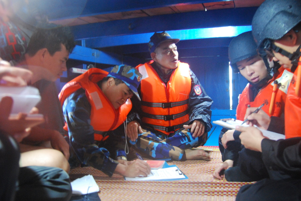 越南海警检查越南渔船登记证书、渔业生产捕捞证、船长船长证等必备证件。（图片来源：越通社）