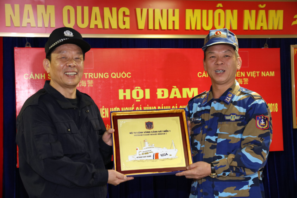 2018年第一次越中海警北部湾共同渔区联合检查活动4月26日进入尾声。在此次巡航路线终点第9个地点，越南海警舰队指挥长、一区司令部副司令陈文诗大校同中方海警舰队指挥长、中国海警局南海分局副局长刘添荣举行海上会晤，总结联检行动成果。图为越南海警第一区司令部陈文诗大校向中国海警局南海分局副局长刘添荣赠送纪念品。（图片来源：越通社）