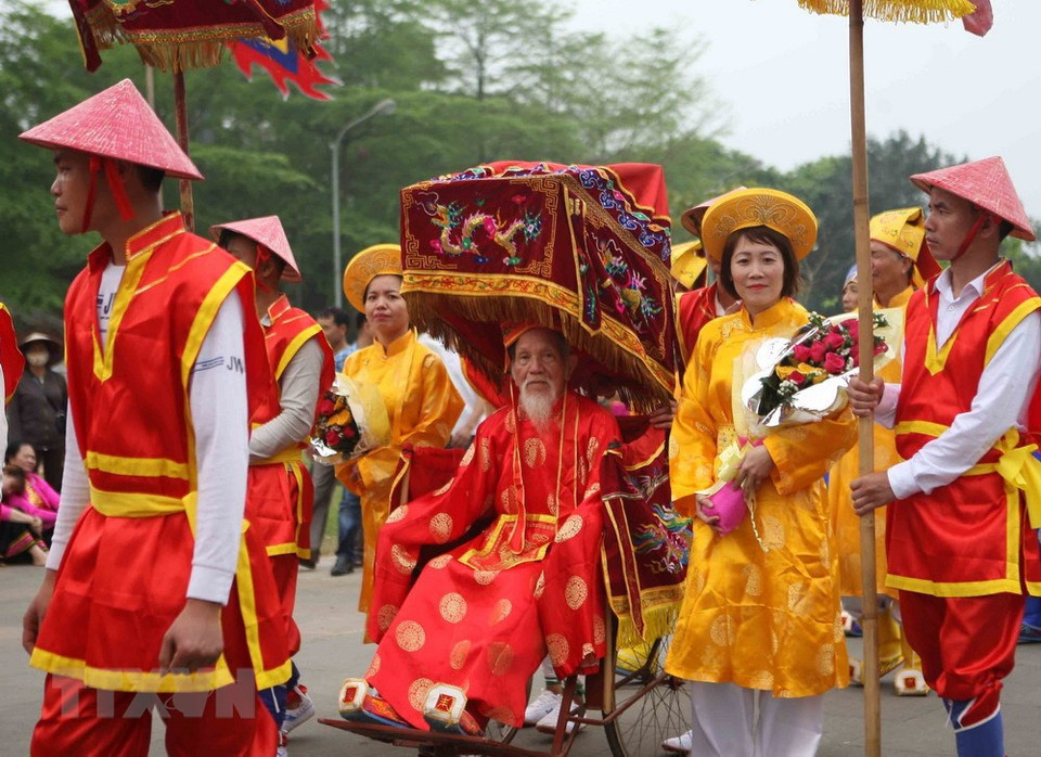 穿着五颜六色的迎轿团以及绚丽多彩的旗帜吸引众多游客的眼球。越通社记者 青松 摄