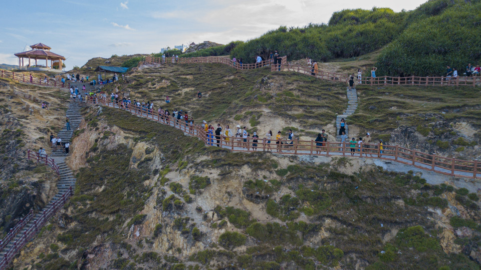 风峡拥有陡峭的悬崖，海拔近 200米。 这个风景区最独特的地方是在退潮时，海滩露出布满绿色苔藓的岩石，碧绿的海水闪闪起伏。图自越通社