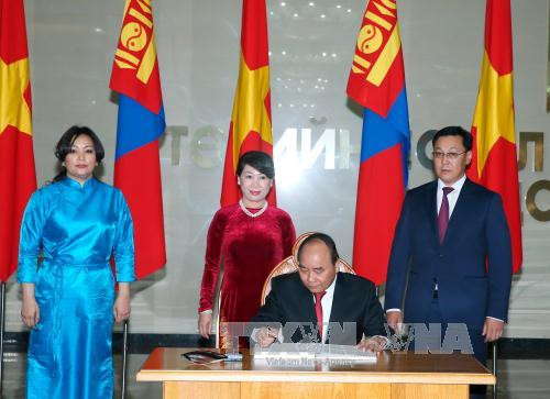 阮春福总理在蒙古国国家宫的留言簿上留言。（图片来源：越通社）