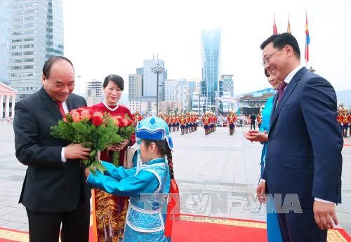 蒙古儿童向阮春福总理赠送鲜花。（图片来源：越通社）
