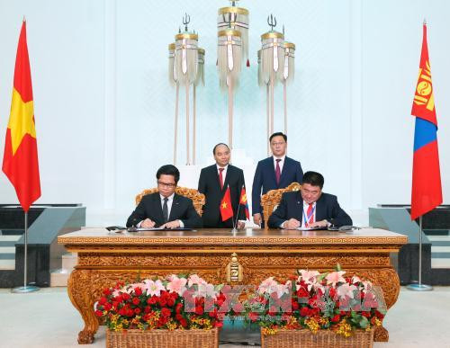越南政府总理阮春福与蒙古国总理额尔登巴特见证了越南工商会同蒙古国雇主联盟的合作备忘录签署仪式。（图片来源：越通社）