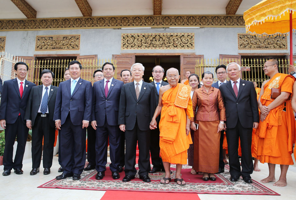 越共中央总书记阮富仲一行和柬埔寨乌那隆寺佛教大众部僧王德旺合影。（图片来源：越通社）