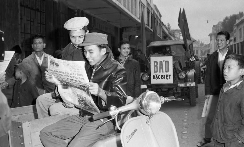 河内市民看报纸，更新1973年1月27日在巴黎签署的《关于在越南结束战争，恢复和平的巴黎协定》的相关信息，越通社发