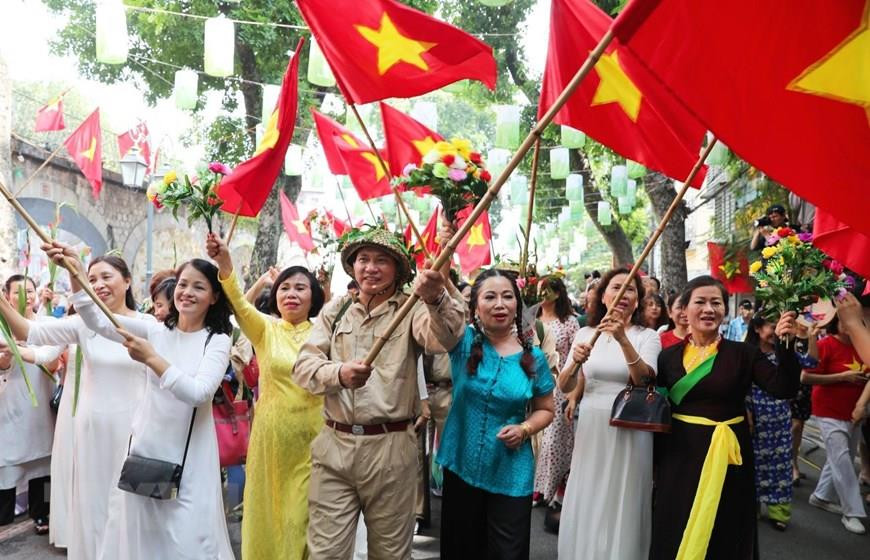 首都人民兴高采烈迎接凯旋归来的军团场景再现。越通社记者 日英 摄