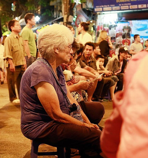 外国游客开心地与街头音乐队一起表演。（图片来源：《人民军队报》）