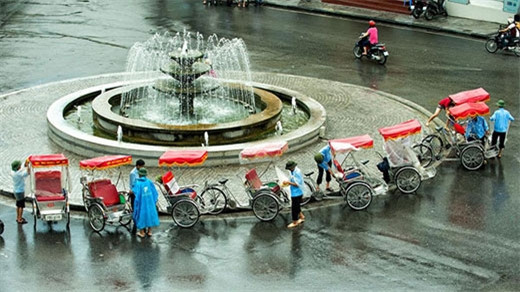 下雨天，三轮车一般穿上白色雨衣，旨在不阻碍游客视线。（图片来源：越南《人民军队报》）