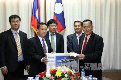 越通社社长阮德利向老挝巴特寮通讯社社长孙通赠送礼物。（图片来源：越通社）