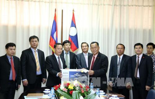 越通社社长阮德利向老挝巴特寮通讯社社长孙通赠送礼物。（图片来源：越通社）