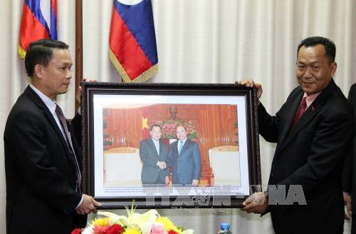 越通社社长阮德利向老挝巴特寮通讯社社长孙通赠送礼物。（图片来源：越通社）