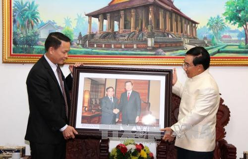 越南通讯社社长阮德利一行获老挝政治局委员、政府副总理潘坎•维帕万（Phankham Viphavan）接见 。（图片来源：越通社）