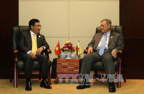  出席第49届东盟外长会议期间，越南政府副总理兼外交部部长范平明会见文莱外交和贸易部第二部长林玉成。