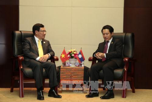  出席第49届东盟外长会议期间，越南政府副总理兼外交部部长范平明会见老挝外长沙伦塞。