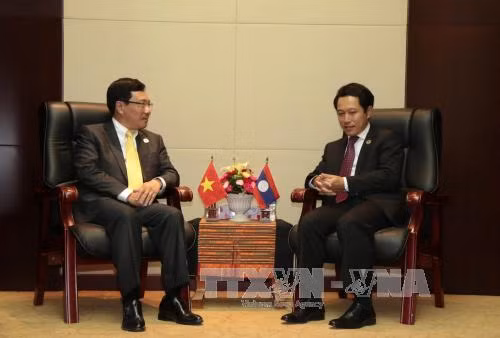  出席第49届东盟外长会议期间，越南政府副总理兼外交部部长范平明会见老挝外长沙伦塞。