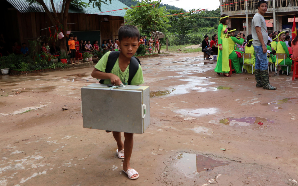 由于下雨、道路湿滑、溪流湍急，一名学生来不及参加新学期开学典礼。 越通社记者 越皇 摄
