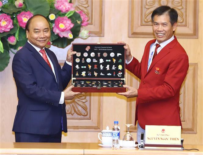  越南体育总局副局长、越南2018年亚运会体育代表团团长陈德粉向阮春福总理赠送礼品。 越通社记者统一 摄