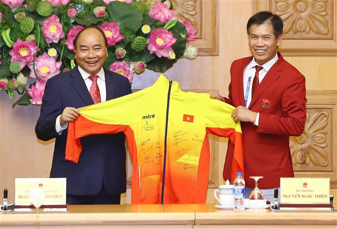  越南体育总局副局长、越南2018年亚运会体育代表团团长陈德粉向阮春福总理赠送礼品。 越通社记者统一 摄