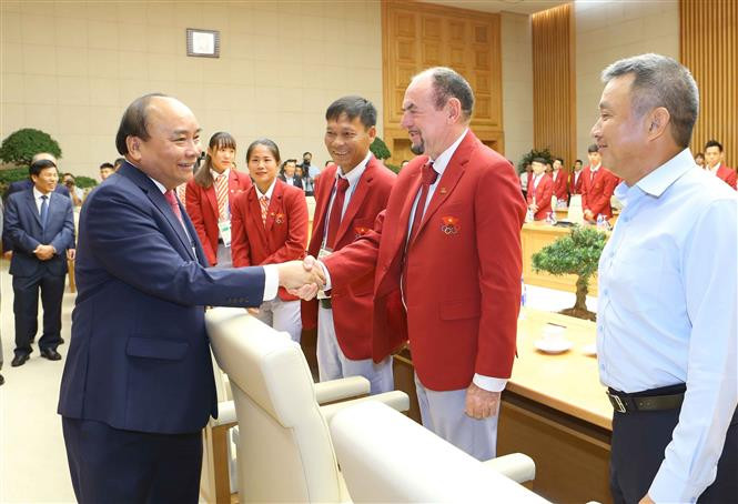 阮春福总理与各位教练员亲切握手。 越通社记者统一 摄