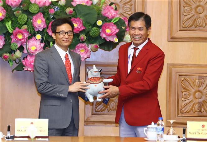  越南体育总局副局长、越南2018年亚运会体育代表团团长陈德粉向越南政府副总理武德儋赠送礼品 。越通社记者统一 摄