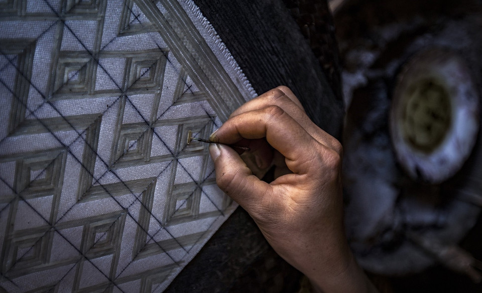 工匠们用蜂蜡在锦缎面料上画上各种花纹。图自 越通社