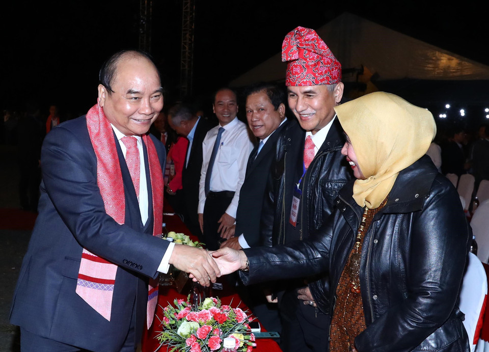 政府总理阮春福和出席活动的代表们握手。图自越通社