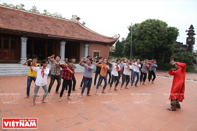 裴文雄艺人给村里学生传授春谱戏技艺。越南画报记者 陈功达 摄