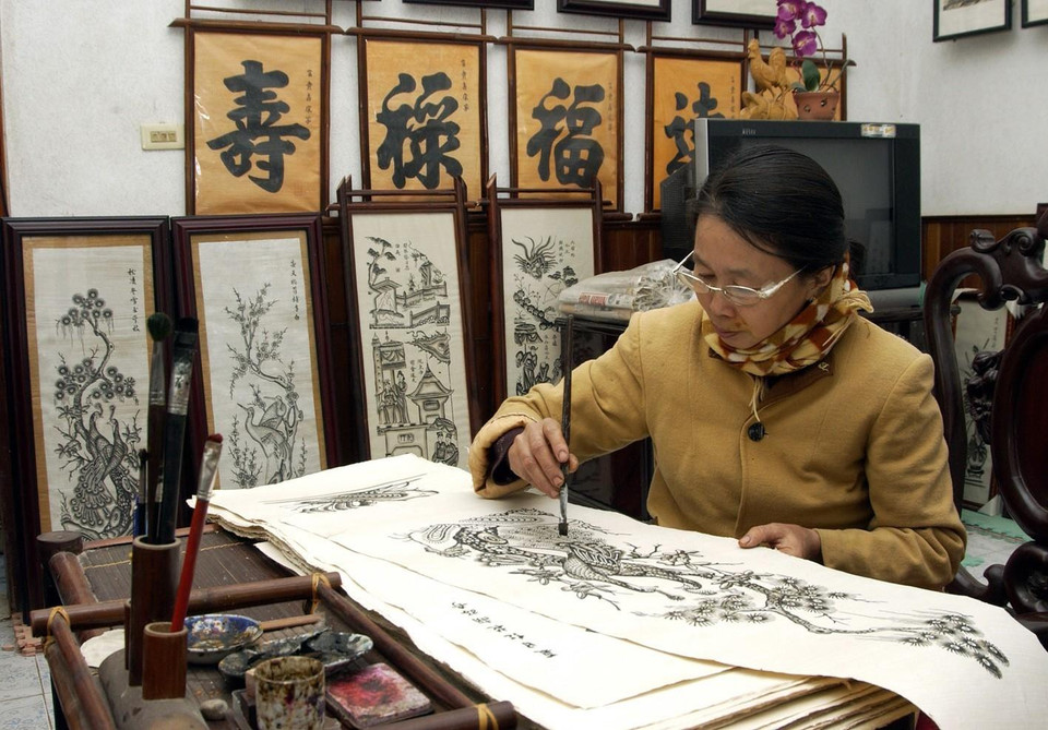 东胡村的阮氏莺女士正在制作民间画。图自越通社