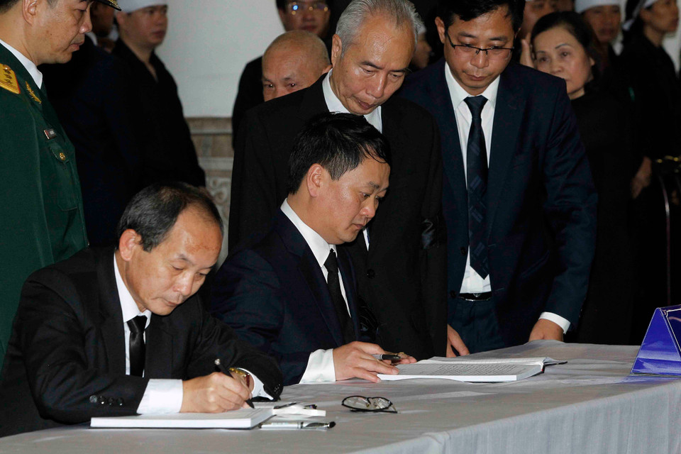 越共中央委员、越南祖国阵线中央委员会副主席兼秘书长候阿令（右）在吊唁簿上留言。图自越通社