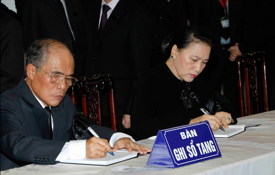 越南国会主席阮氏金银（右）和原国会主席阮生雄在吊唁簿上留言。图自越通社