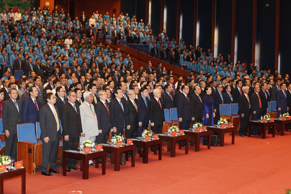 与会代表向国旗敬礼。 图自越通社