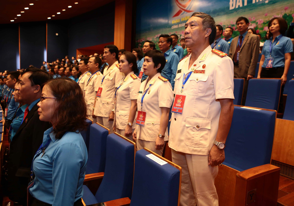 与会代表向国旗敬礼。 图自越通社