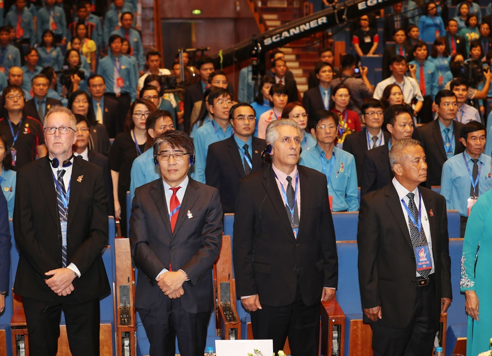 与会代表向国旗敬礼。 图自越通社