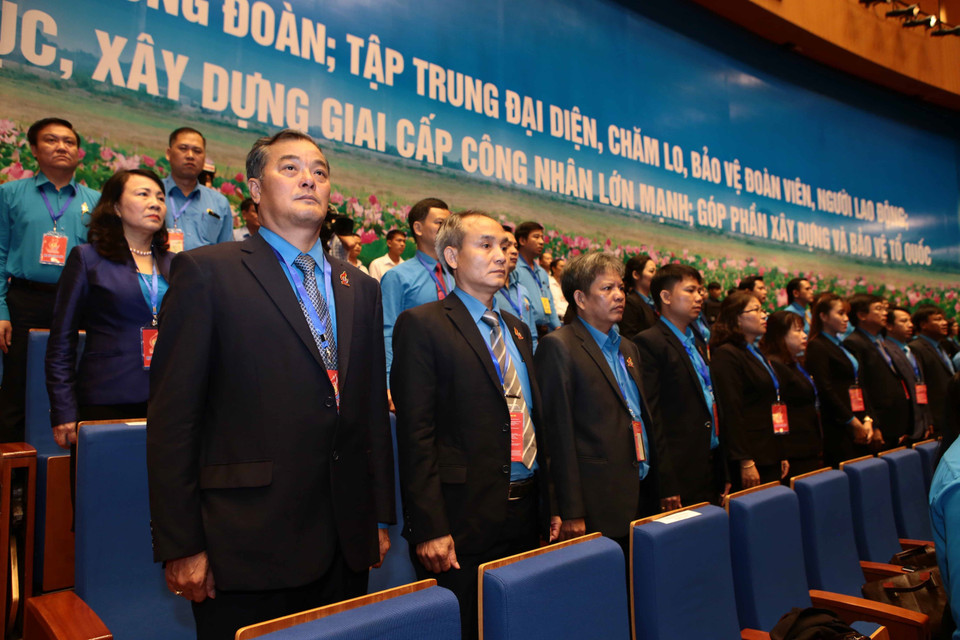 与会代表向国旗敬礼。 图自越通社