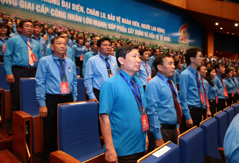 与会代表向国旗敬礼。 图自越通社