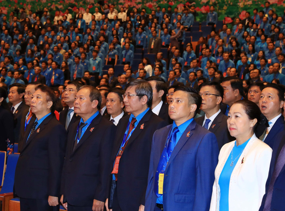 与会代表向国旗敬礼。 图自越通社